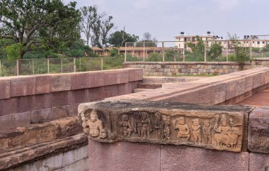 Aihole, Karnataka, Hindistan - 7 Kasım 2013: Huchchimalli Gudi veya Temple. Açık mavi gökyüzü ve yeşil yeşilliklerin altında, tankın duvarındaki küçük kahverengi taş fresk..