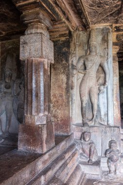 Aihole, Karnataka, Hindistan - 7 Kasım 2013: Ravanaphadi Mağarası Shiva Tapınağı. Gri taşlı insan figürü heykeller, bir sıra küçük figürün üzerinde..