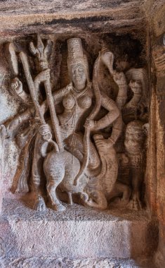 Aihole, Karnataka, Hindistan - 7 Kasım 2013: Ravanaphadi Mağarası Shiva Tapınağı. Kahverengi taş heykel Tanrıça Durga mızrakla bufaloyu yeniyor. 
