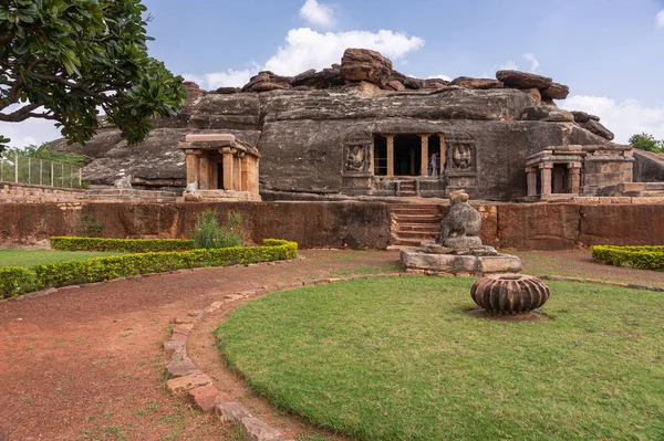 アイホール カルナータカ インド 2013年11月7日 ラバナパディー洞窟シヴァ寺院 青い雲の下に茶色の石造りの建物の追加と黒の岩 目の前の緑の芝生と公園 — ストック写真