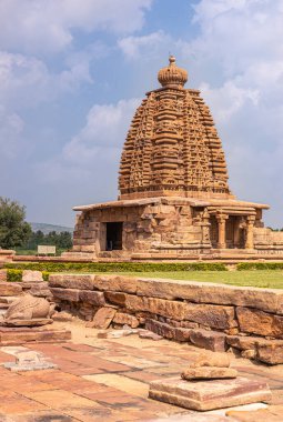 Bagalakote, Karnataka, Hindistan - 7 Kasım 2013: Pattadakal Tapınağı Kompleksi. Uzun kahverengi taş Galaganatha Tapınağı vimanam kulesi ve mavi bulutların altındaki sığınak.