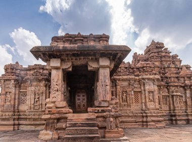Bagalakote, Karnataka, Hindistan - 7 Kasım 2013: Pattadakal Tapınağı Kompleksi. Mavi bulutların altındaki kahverengi taştan Viruipaksha tapınağının anıtsal girişi.