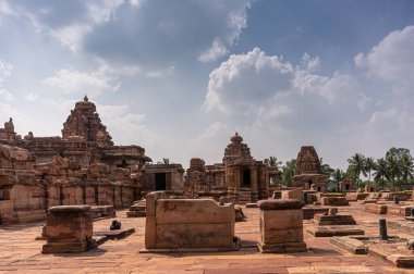 Bagalakote, Karnataka, Hindistan - 7 Kasım 2013: Pattadakal Tapınağı Kompleksi. Kahverengi taştan bir manzara harap olmuş tapınak binaları ve daha çok mavi bulutların altında,