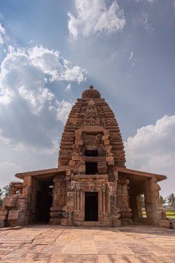 Bagalakote, Karnataka, Hindistan - 7 Kasım 2013: Pattadakal Tapınağı Kompleksi. Uzun kahverengi taş Galaganatha Tapınağı vimanam kulesine mavi bulutların altında bir roket gibi yakın çekim.