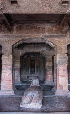 Badami, Karnataka, Hindistan - 7 Kasım 2013: Agasthya Gölü üzerindeki mağara tapınakları. Nandi heykeli Shivalingam 'la birlikte tapınağın önünde. Ağır kahverengi taş sütunlar ve kirişler.
