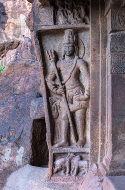 Badami, Karnataka, Hindistan - 7 Kasım 2013: Agasthya Gölü üzerindeki mağara tapınakları. Girişinde mızrak heykeli olan sert gri taş cüce alaka 'nın yakın çekimi.. 