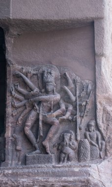 Badami, Karnataka, Hindistan - 7 Kasım 2013: Agasthya Gölü üzerindeki mağara tapınakları. Nataraja 'yı veya dans eden Şiva' yı gösteren gri taş heykelin yakın çekimi. Ağır hasar görmüş. Nandi, Ganesha, Murugan.