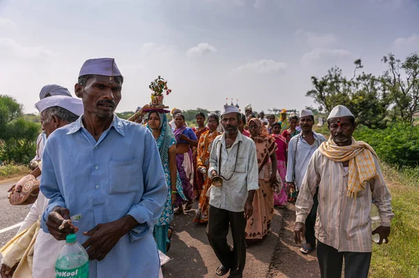 インド カルナータカ州ジャンナイ2013年11月8日 巡礼グループの最前線の人々は 道路脇に緑の葉を持つ青空の下 パンドラプラのクリシュナ寺院に行進しました 女性は頭にタラシの植物を運ぶ — ストック写真