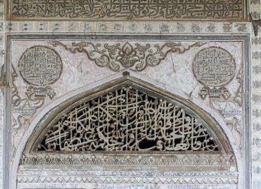 Vijayapura, Karnataka, Hindistan - 8 Kasım 2013: İbrahim Rauza Anıtmezar. Duvardaki gri taştan şekilsiz heykel kemer ve daireler oluşturuyor..