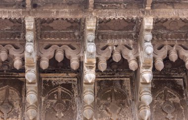 Vijayapura, Karnataka, Hindistan - 8 Kasım 2013: İbrahim Rauza mozolesinde çatı çıkıntısı altında geniş kahverengi taş heykel bölümünün kapatılması.