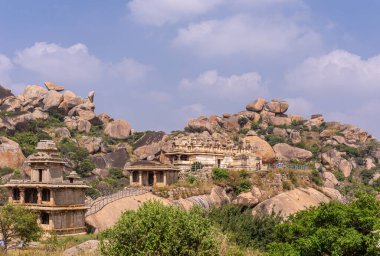 Chitradurga, Karnataka, Hindistan - 10 Kasım 2013: Fort veya Elusuttina Kote. Kahverengi taşlı Hidimbeshwara tapınak kompleksi kaya tepeleri üzerine kurulmuş ve mavi bulutların altında yeşil yapraklar.