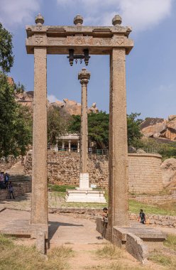 Chitradurga, Karnataka, Hindistan - 10 Kasım 2013: Fort veya Elusuttina Kote. Mavi bulutların altında, Hidambeswara Tapınağı 'nın yakınlarındaki beyaz üste zafer sütunlu Kahverengi Kare Kemeri portresi.