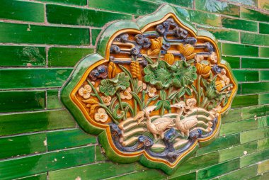 Pekin, Çin - 27 Nisan 2010: Yasak Şehir. Yeşil duvardaki çiçek ve kuş temalı seramik çalışmalarına yakın çekim.