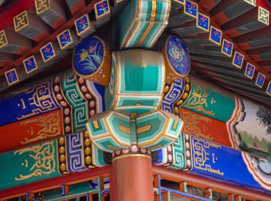 Pekin, Çin - 29 Nisan 2010: Yaz Sarayı. Boyalı ve yontulmuş ahşap kirişlerin yakın çekimi binanın mimarisini bir sürü yeşil, mavi, kırmızı ve altın rengine boyuyor..