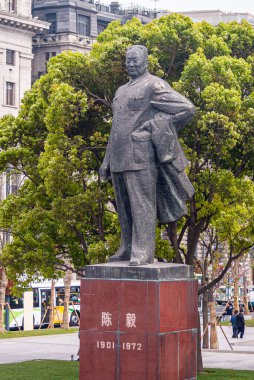 Şangay, Çin - 4 Mayıs 2010: Bund boyunca park halindeki ilk belediye başkanı olan Chen Yi 'nin kırmızı kaidesindeki büyük gri heykelin ön görüntüsü. Trafik ve arkadaki insanlar..