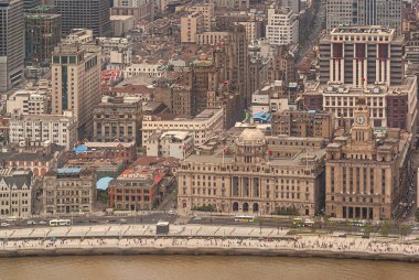 Şangay, Çin - 4 Mayıs 2010: Saat kulesi olan gümrük binası, Bund ve nehir boyunca HSBC binası ve arkasında kahverengi taştan yüksek binalar bulunan şehir ormanı. Hava görüntüsü. Tahta kaldırımdaki insanlar.