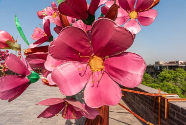 Xian, Çin - 30 Nisan 2010 Huancheng Şehir Duvarı. Kaplan yılı gösterisi. Açık mavi gökyüzüne karşı sahte pembe çiçekler. Biraz yeşil yaprak..