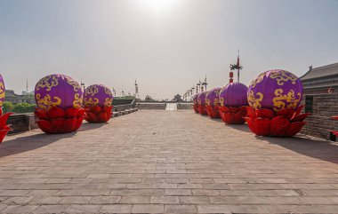 Xian, Çin - 30 Nisan 2010 Huancheng Şehir Duvarı. Kaplan gösterisi yılı. Altın-mor şişirilebilir küreler, gümüş-mavi gökyüzünün altında, surlarda kırmızı bardaklarda dizilmiş..