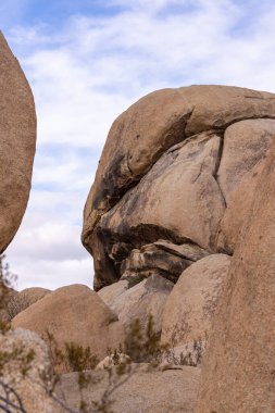 Joshua Tree Ulusal Parkı, CA, ABD - 30 Aralık 2012: Mavi bulutların altında erkek üst yüzü şeklinde bej kayanın yakın plan portresi.