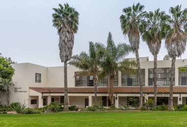 Santa Barbara, CA, USA - 2 Haziran 2021: Şehir kolej tesisleri. Bej Dijital Sanatlar binası aynı zamanda CNEE ve Sağlık Teknolojileri 'ne de ev sahipliği yapar. Açık mavi gökyüzü altında yeşil park ortamında ayarlandı.