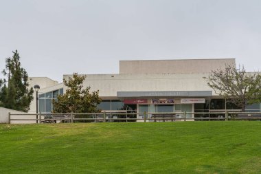 Santa Barbara, CA, USA - 2 Haziran 2021: Şehir kolej tesisleri. Gümüş gökyüzünün altında yeşil çimlerin arkasında gişe hasılatı olan Garvin Tiyatrosu 'nun ön manzarası. Kenarlarında yeşil yapraklar.