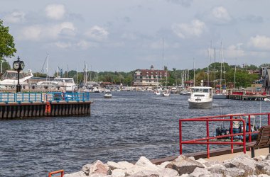 South Haven, MI, ABD - 7 Haziran 2008: Kara Nehir 'deki Marina limanından Michigan Gölü' ne çıkış kanalına giriş görüntüsü açık mavi bulutlar altında bir sürü eğlence teknesi gösteriyor..
