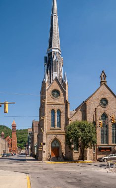 Johnstown, PA, USA - 11 Haziran 2008: Franklin caddesinde Birleşik Metodist Kilisesi ve arkasında Saint John Gualbert Katedrali 'nin iki kulesi bulunan kırmızı tuğlalı bina. 