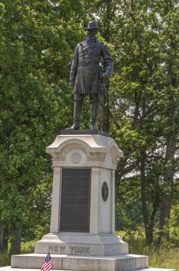 Gettysburg, PA, USA - 15 Haziran 2008: Savaş alanı anıtları. Tümgeneral John Cleveland Robinson 'un New York' taki koyu bronz heykeli, arkasında Amerikan bayrağı ve yeşil yeşillik olan kaideye yakın çekim.