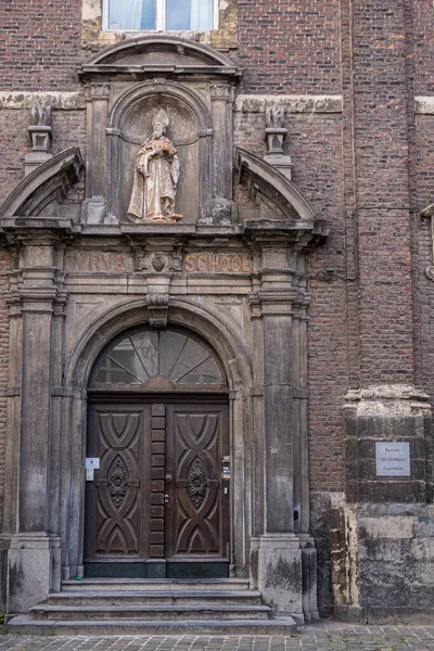 ヘント フランダース ベルギー 2021年7月30日 アウグスティヌス修道院の聖シュテファン教会の暗いレンガ造りの入り口の壁の茶色のドア 山頂に立つ聖像 — ストック写真