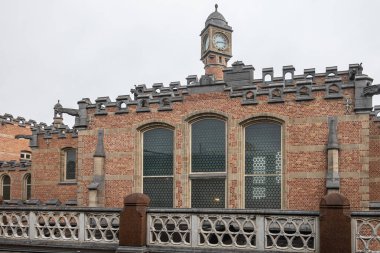 Gri gökyüzünün altındaki raylardan Sint Pieters tren istasyonunun ince kırmızı tuğlalı saat kulesine bakın..