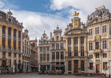 Brüksel, Belçika - 31 Temmuz 2021: Grand Place 'in SW tarafındaki tarihi Lonca evleri mavi bulutların altında. Altın heykeller ve süsler. 