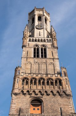Brugge, Flanders, Belçika - 4 Ağustos 2021: Çan kulesinin bir parçası olarak mavi gökyüzüne karşı Halletoren 'in kahverengi tuğla üst yarısının kapatılması.