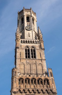 Brugge, Flanders, Belçika - 4 Ağustos 2021: Çan kulesinin bir parçası olarak mavi gökyüzüne karşı Halletoren 'in kahverengi tuğlası.
