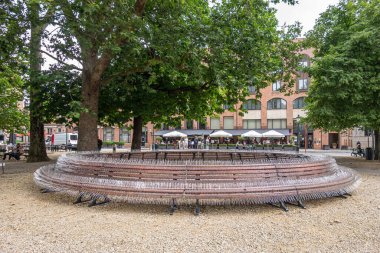 Brugge, Flanders, Belçika - 4 Ağustos 2021: Burg Meydanı 'ndaki yuvarlak bank insanların birlikte oturmasını engellemek için güvercin veya kuş çivileriyle süslendi. Hepsi Covid19 'un önlenmesi için. Yeşil yaprak.