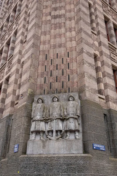 アムステルダム オランダ 2021年8月13日 VijzelstraatとHerengrachtの角にある背の高い茶色の石造りのオフィスビルDe Bazelの下にアンカーを保持する3人の船員の灰色の彫像 フレスコ画 — ストック写真