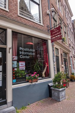 Amsterdam, Hollanda - 14 Ağustos 2021: Önünde çiçekler bulunan Enge Kerksteeg 'de geniş pencereli Fuhuş Bilgi Merkezi. 