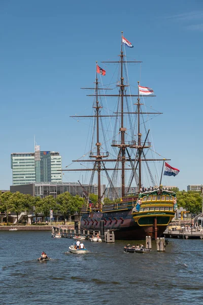 Amsterdam, Hollanda - 15 Ağustos 2021: Tarihsel otantik 3 direkli yelkenli gemisi Barquentine-model adını mavi gökyüzü altında küçük teknelerle denizde yüzen.