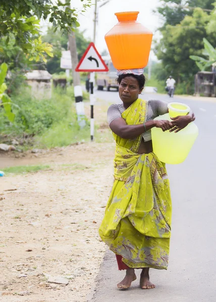 Mujer lleva dos jarras de agua . —  Fotos de Stock