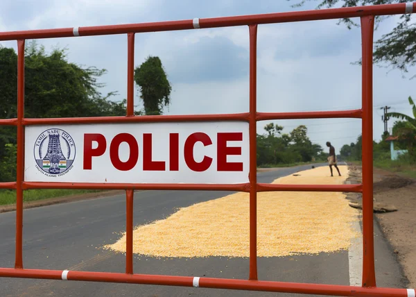Policejní bariéry chrání sušení kukuřice na silnici. — Stock fotografie