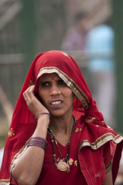 Kadın kırmızı onun başörtüsü ile sağ elini tutar.