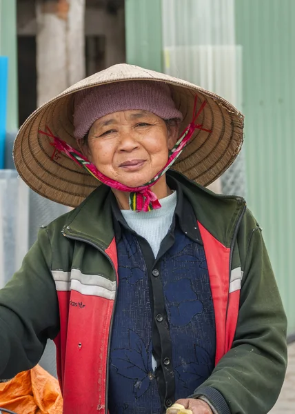 Vietnamská žena středního věku s tradičními slaměný klobouk. — Stock fotografie