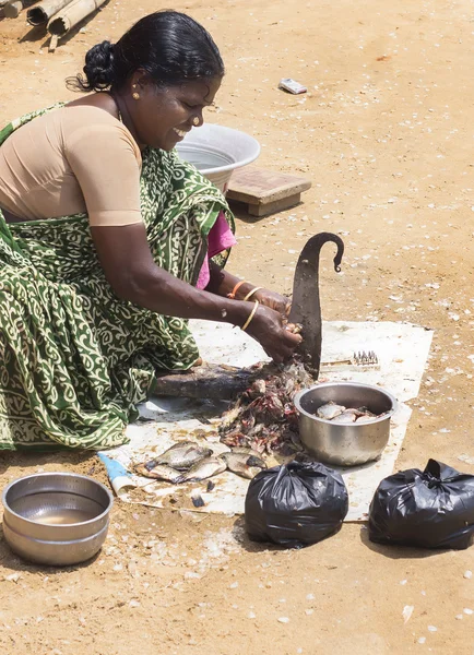 Vrouw reinigt en snijdt vis. — Stockfoto