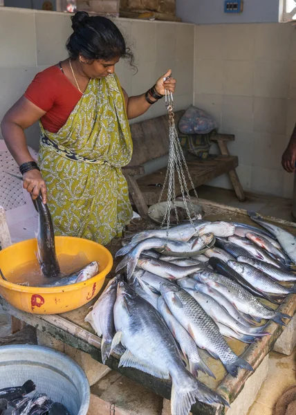 Frau wiegt und verkauft große Fische auf dem Markt. — Stockfoto