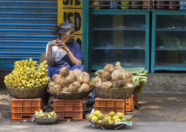 Woman sells coconuts and bananas. — Stock Photo, Image