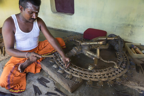 Man corrects statue impurities coming out of cast.