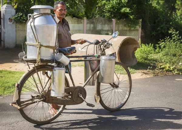 Milkman cargando latas de leche en su bicicleta . —  Fotos de Stock