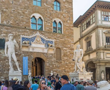 Firenze, İtalya, Avrupa - 14 Temmuz 2024: David heykeli, Herkül ve Cacus heykeli, Piazza della Signoria 'da yan yana. Müzenin önünde kare isimli bir sürü yaya var.