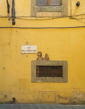 Firenze, İtalya, Avrupa - 14 Temmuz 2024: Kiler penceresinin üstünde Via Dell Anguillara 'daki ev duvarında melek görüntüsü belirdi.