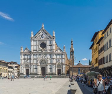 Firenze, İtalya, Avrupa - 14 Temmuz 2024: Santa Croce Bazilikası mavi gökyüzüne karşı beyaz cephe. Saat kulesi yan tarafta. Dante Alighieri anıtı, solda..