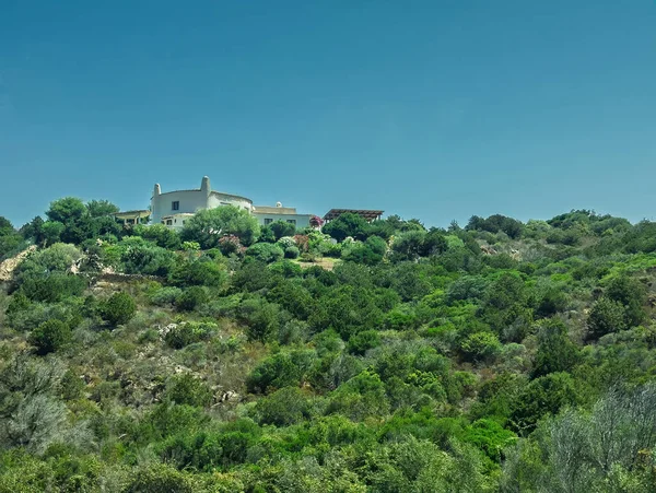 Porto Cervo, Sardinya, İtalya - 15 Temmuz 2024: Kosta Smeralda 'daki lüks tatil köyü. Limanın üstündeki tepelerde büyük bir malikane.